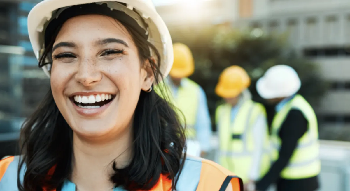 Smiling construction worker in a hard hat on site