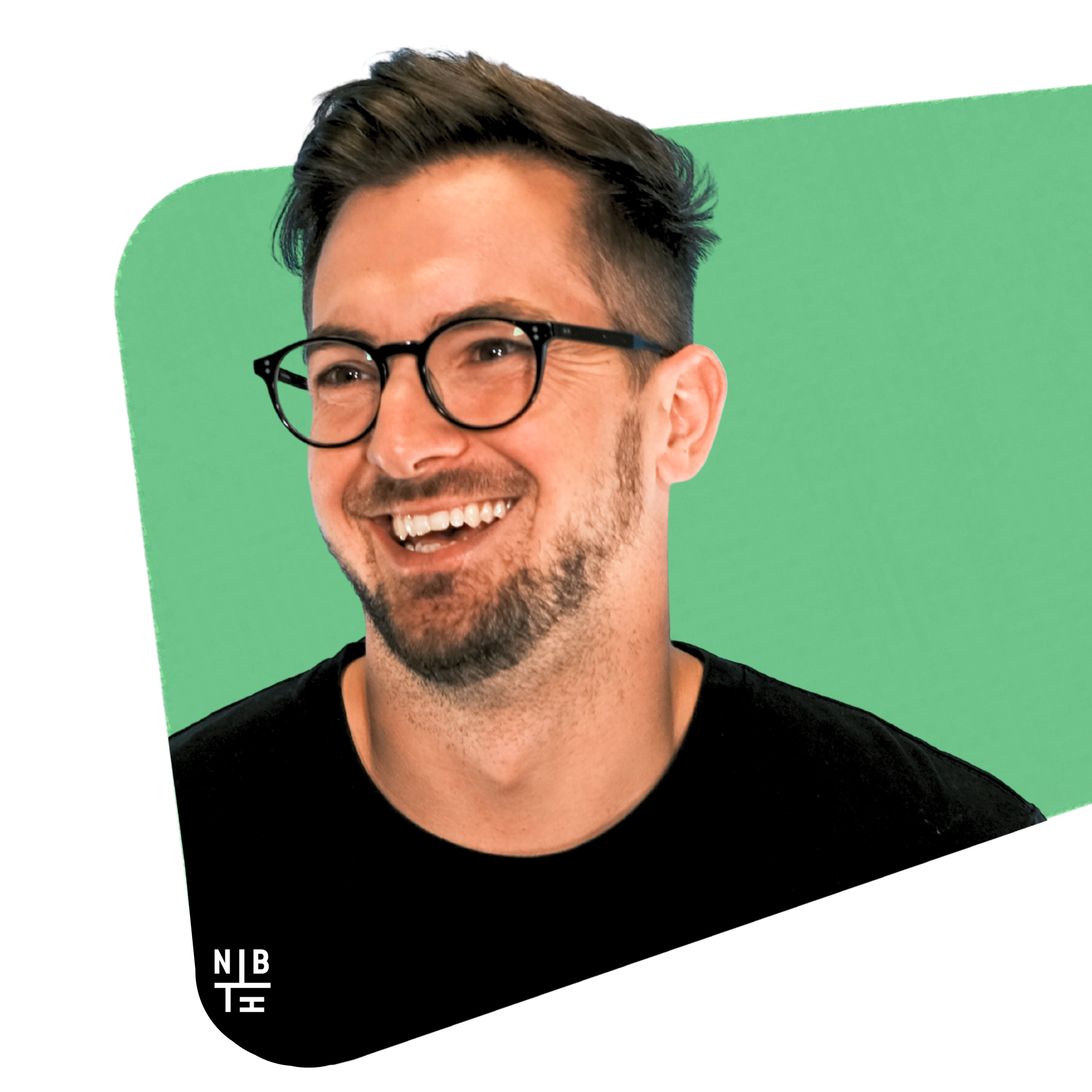 Smiling man in glasses and a black tee on a green shape